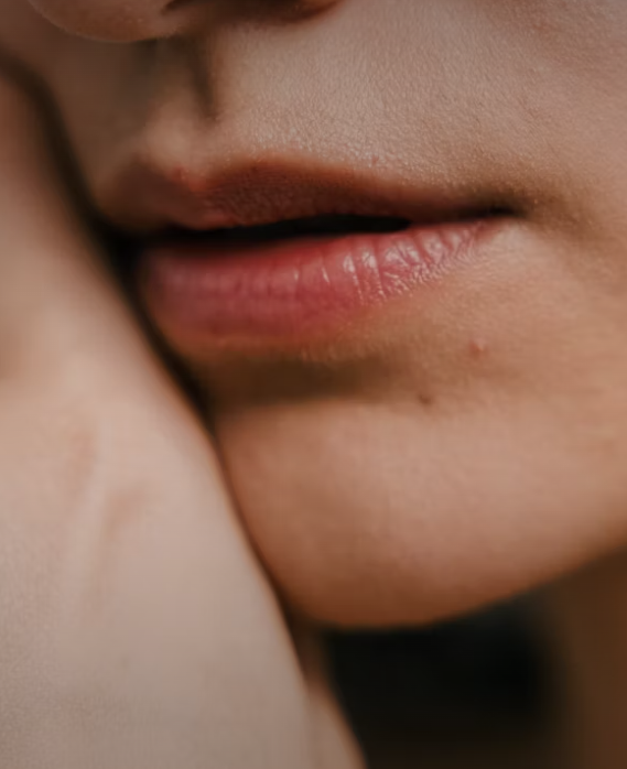 Applying a golden herbal lip balm to protect against wind and cold weather.